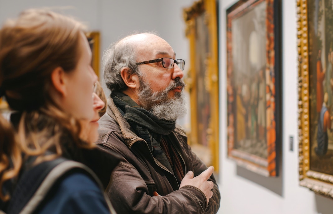 Guests observing paintings at an art gallery.