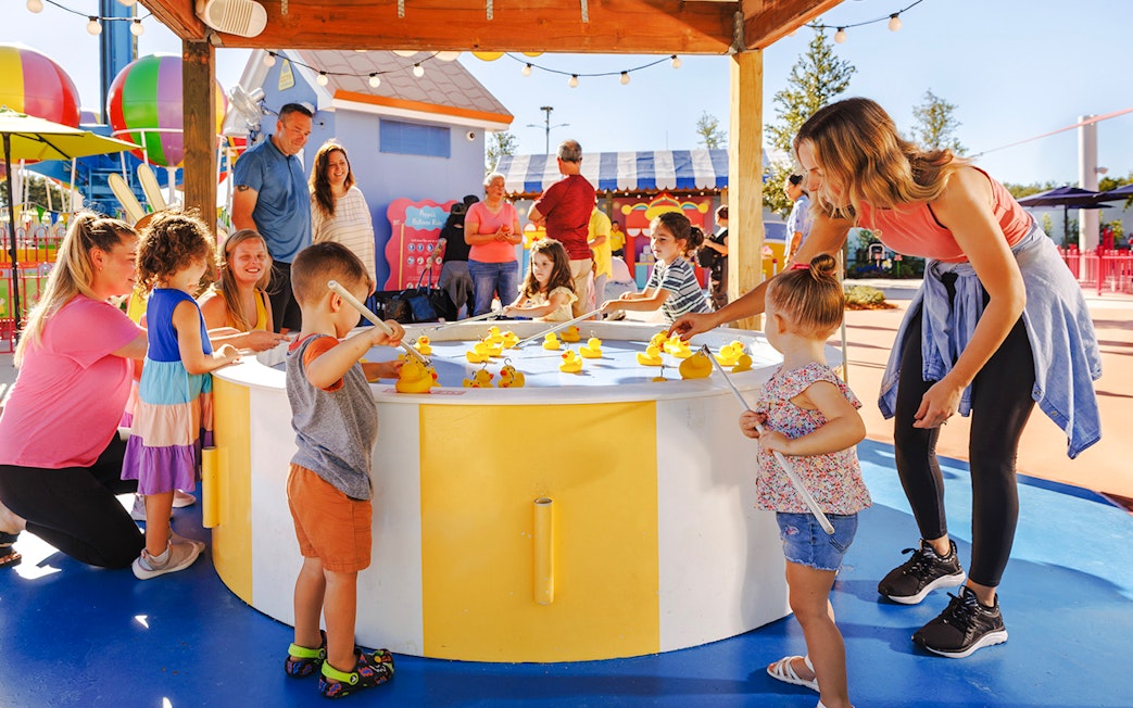Children playing a duck fishing game at Peppa Pig Theme Park, Florida.
