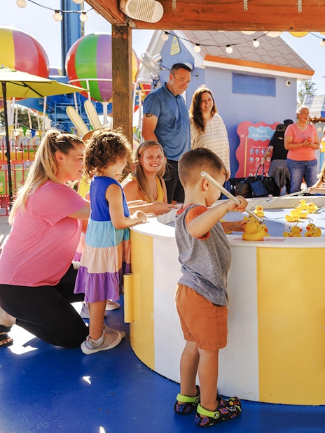Children playing a duck fishing game at Peppa Pig Theme Park, Florida.
