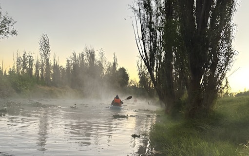 Kayaking at sunrise through misty canals in Xochimilco.