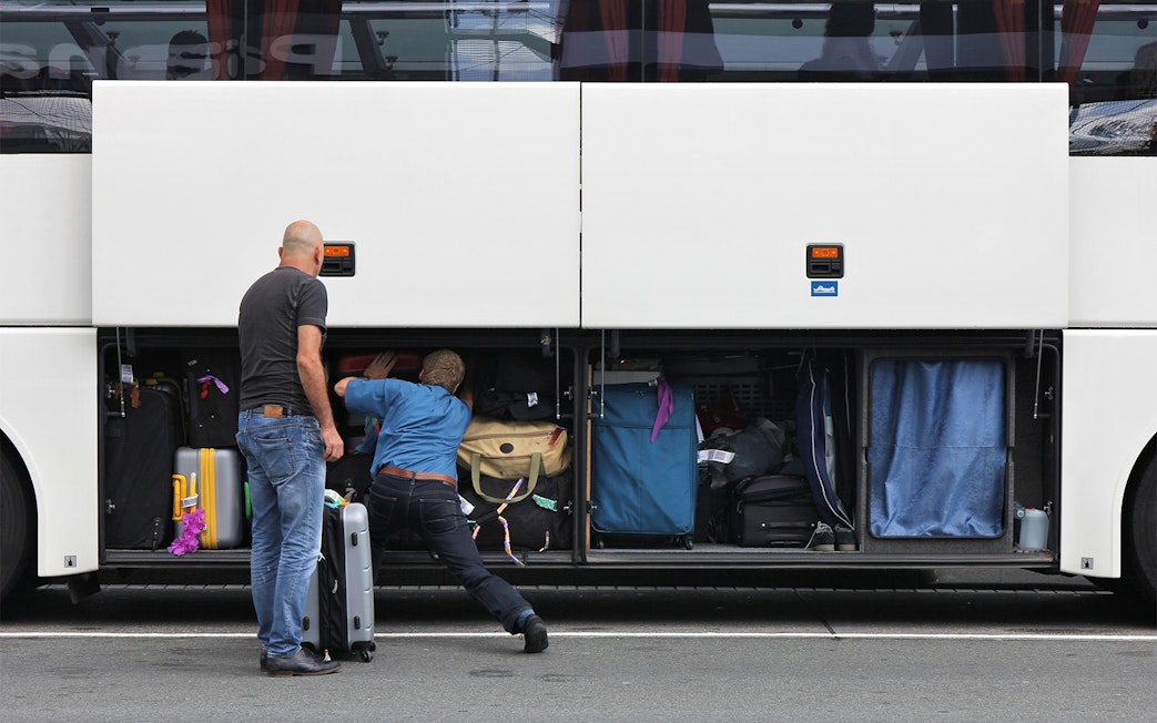 Passengers loading luggage into a bus compartment for Roma Linee one-way tickets from Rome Fiumicino Airport.