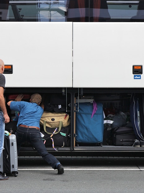 Passengers loading luggage into a bus compartment for Roma Linee one-way tickets from Rome Fiumicino Airport.
