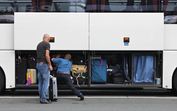 Passengers loading luggage into a bus compartment for Roma Linee one-way tickets from Rome Fiumicino Airport.