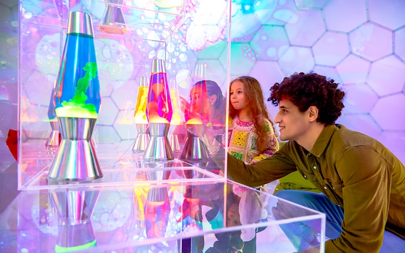 Visitors exploring colorful lava lamps at Bubble Planet exhibit, Washington DC.