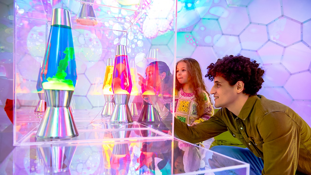 Visitors exploring colorful lava lamps at Bubble Planet exhibit, Washington DC.