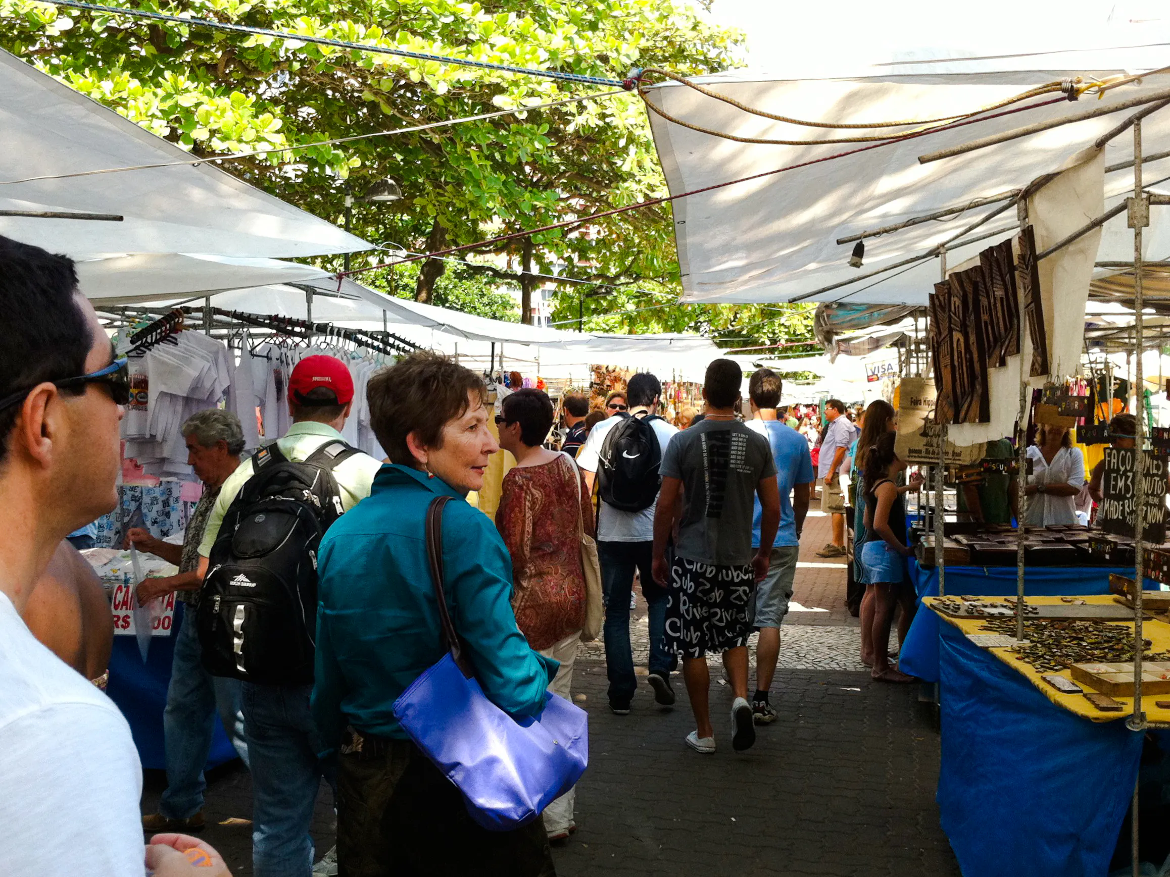 Visitors exploring Ipanema Street Market stalls with local crafts in Rio de Janeiro.