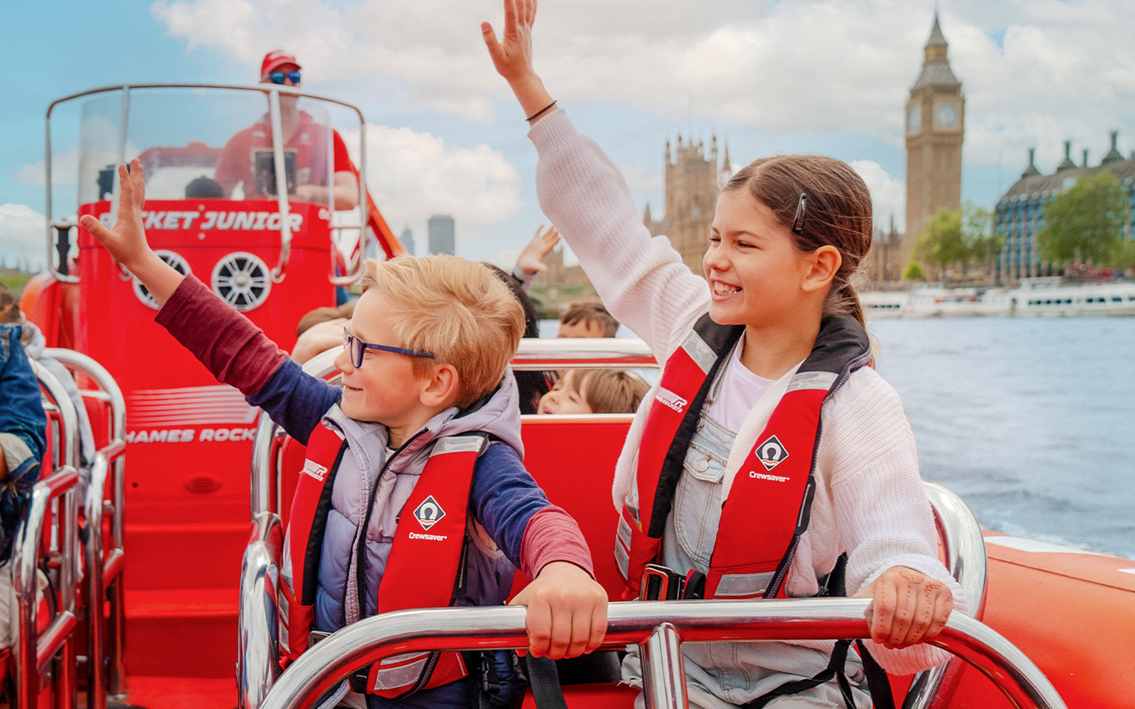 Children enjoying a Thames speed boat ride with Big Ben in the background.