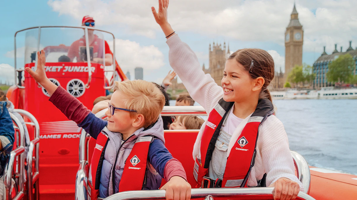 Children enjoying a Thames speed boat ride with Big Ben in the background.