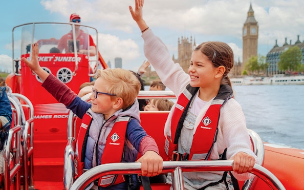 Children enjoying a Thames speed boat ride with Big Ben in the background.