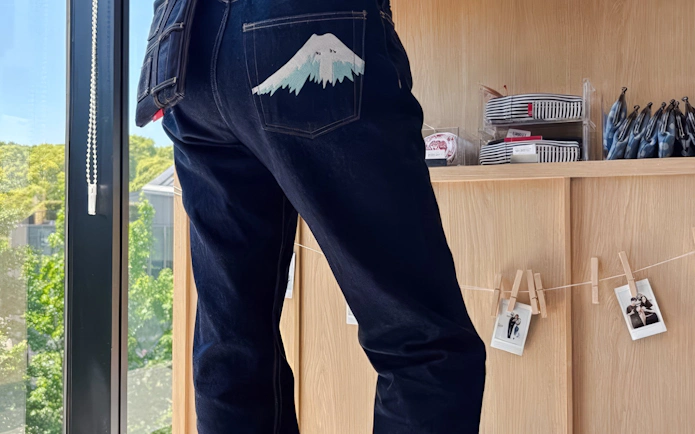 Jeans with Mount Fuji design on back pocket at Tokyo denim workshop.