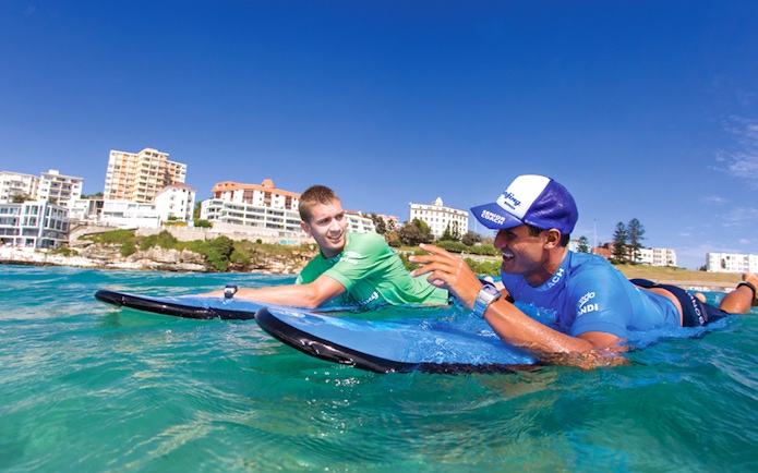 Surf instructor and student on surfboards at Bondi Beach, Sydney.