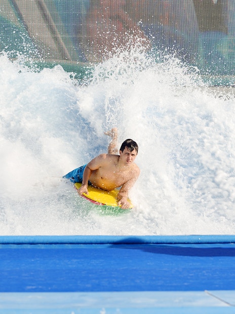 Surfer riding artificial wave at Yas Waterworld Abu Dhabi.