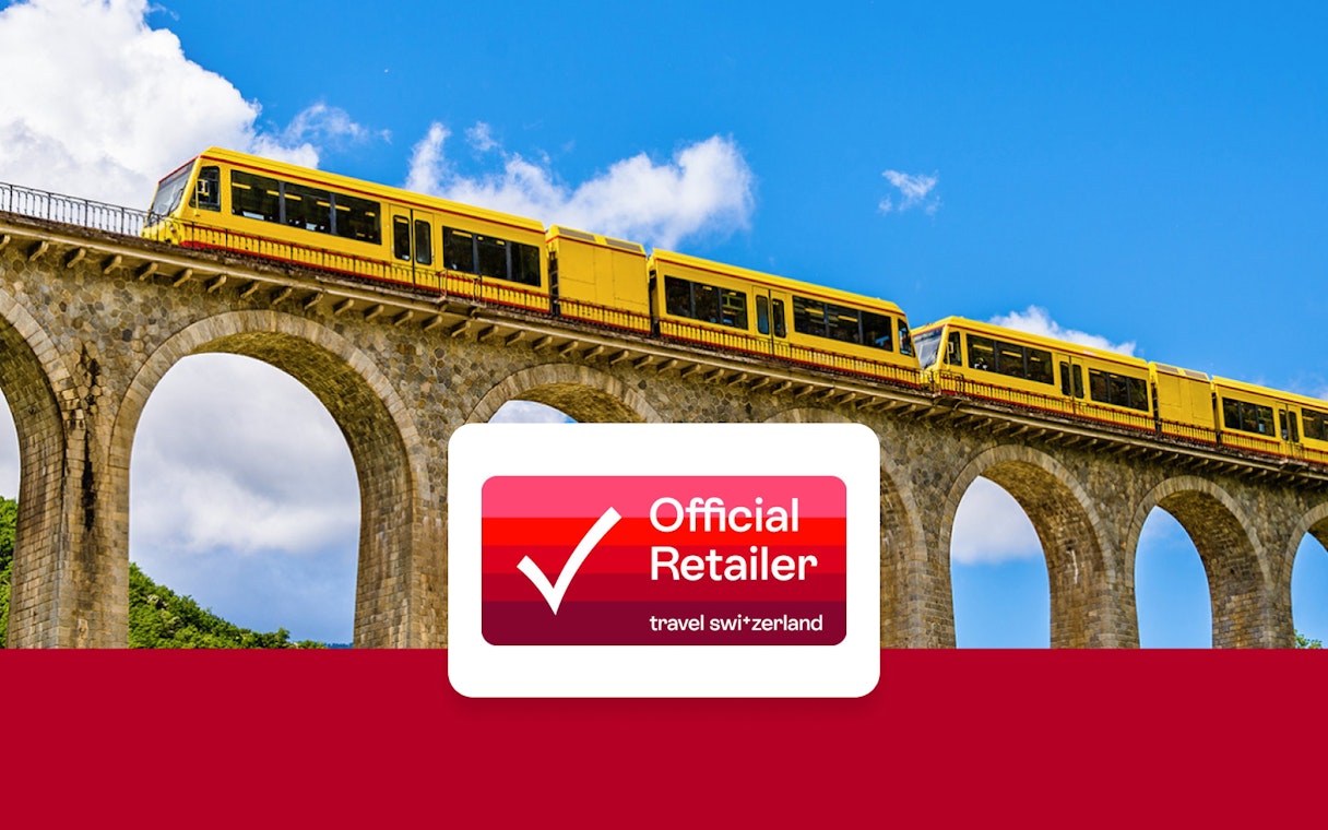 Yellow train crossing a stone viaduct under a blue sky, promoting Interrail Global Mobile Pass Flex.