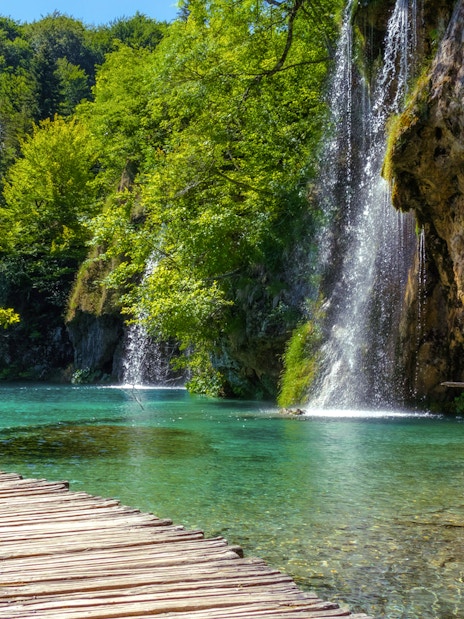 Wooden path beside waterfalls at Plitvice Lakes National Park, Croatia.