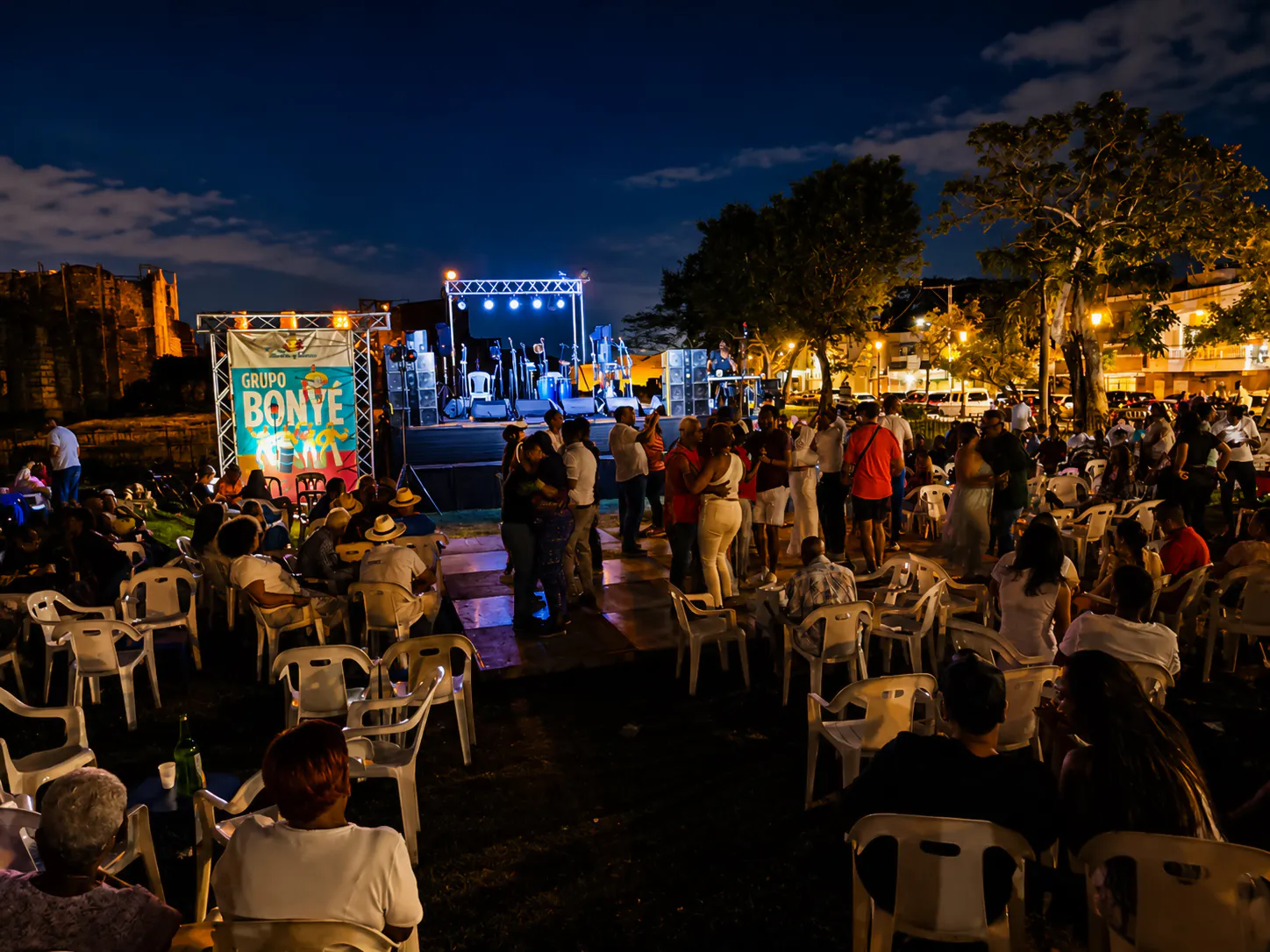 Outdoor live music event in Santo Domingo with people gathered near a stage at night.