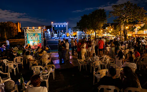 Outdoor live music event in Santo Domingo with people gathered near a stage at night.
