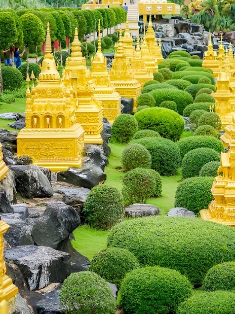 Golden pagodas and manicured greenery at Nong Nooch Tropical Garden, Thailand.