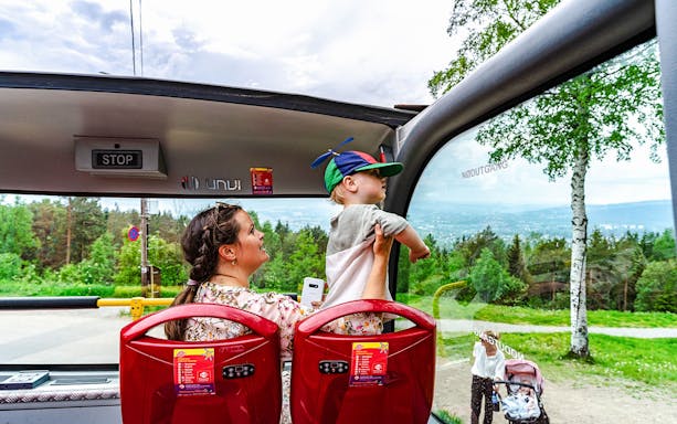 Mother and child enjoying view from top tier on Stavanger hop-on hop-off bus.