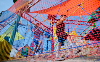 Children navigating colorful rope course at Ko Fun Kids Rope Park, Phuket.