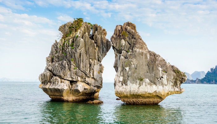 Kissing Rocks in Halong Bay, Vietnam, surrounded by calm sea and clear sky.