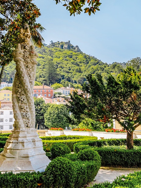 Sintra National Palace Gardens with ornate column and lush greenery.