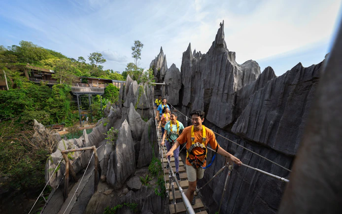 Visitors crossing a suspension bridge at Rainforest Wild Adventure.