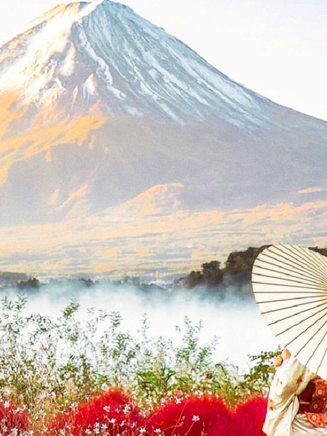 Woman in kimono with umbrella in front of Mount Fuji, Japan.