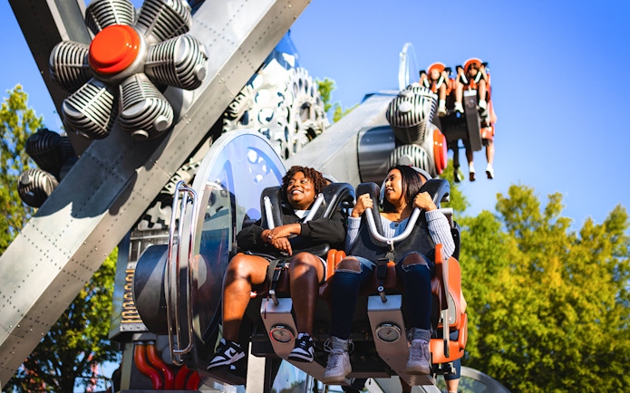 Riders enjoying the Gear Spin ride at Six Flags Carowinds.