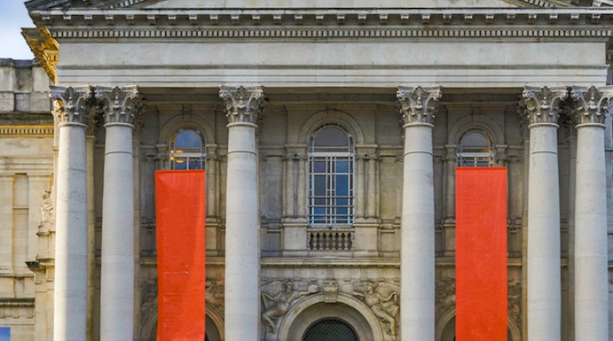 Tate Britain entrance with neoclassical columns and red banners, London.