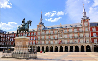 Plaza Mayor in Madrid with equestrian statue and historic buildings.
