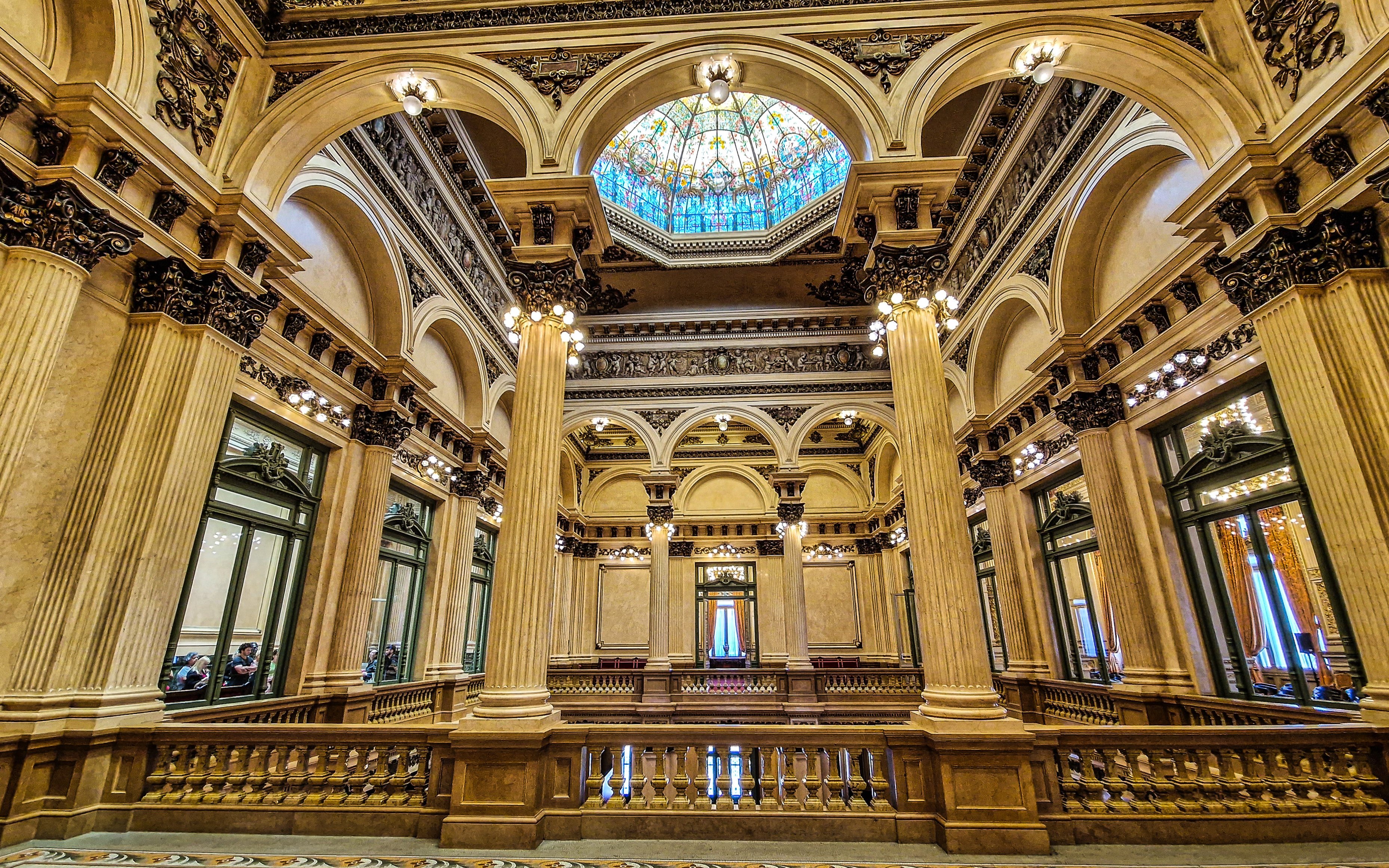 Interior of Teatro Colon, showcasing ornate columns and stained glass ceiling in Buenos Aires, Argentina.