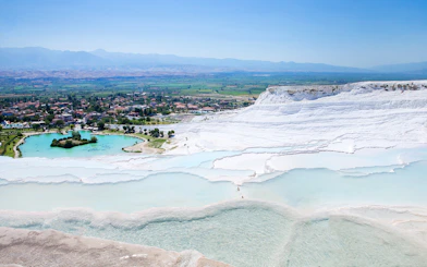Terraced thermal pools of Pamukkale with distant view of the town, on a guided day tour from Antalya.
