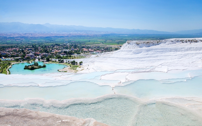 Terraced thermal pools of Pamukkale with distant view of the town, on a guided day tour from Antalya.
