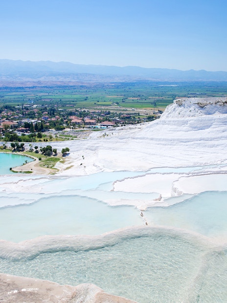 Terraced thermal pools of Pamukkale with distant view of the town, on a guided day tour from Antalya.