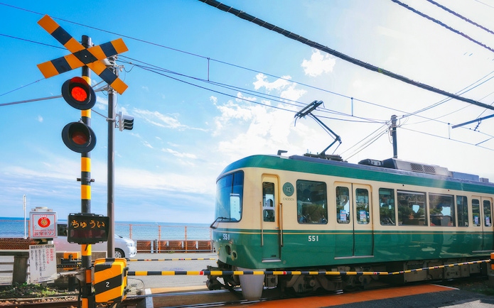 Enoshima Electric Railway train crossing near the coast in Kamakura, Japan.