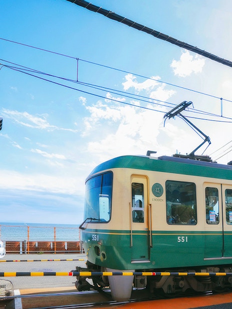 Enoshima Electric Railway train crossing near the coast in Kamakura, Japan.