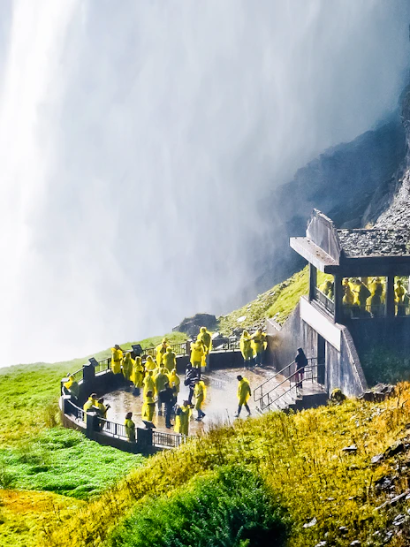 Visitors in yellow ponchos on the Journey Behind the Falls deck at Niagara Falls.