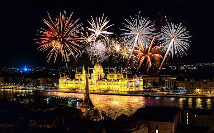 Budapest fireworks over the illuminated Parliament building during a river cruise.