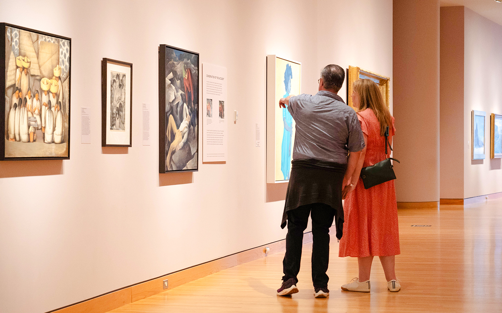 Couple viewing paintings at Seattle Art Museum exhibition.