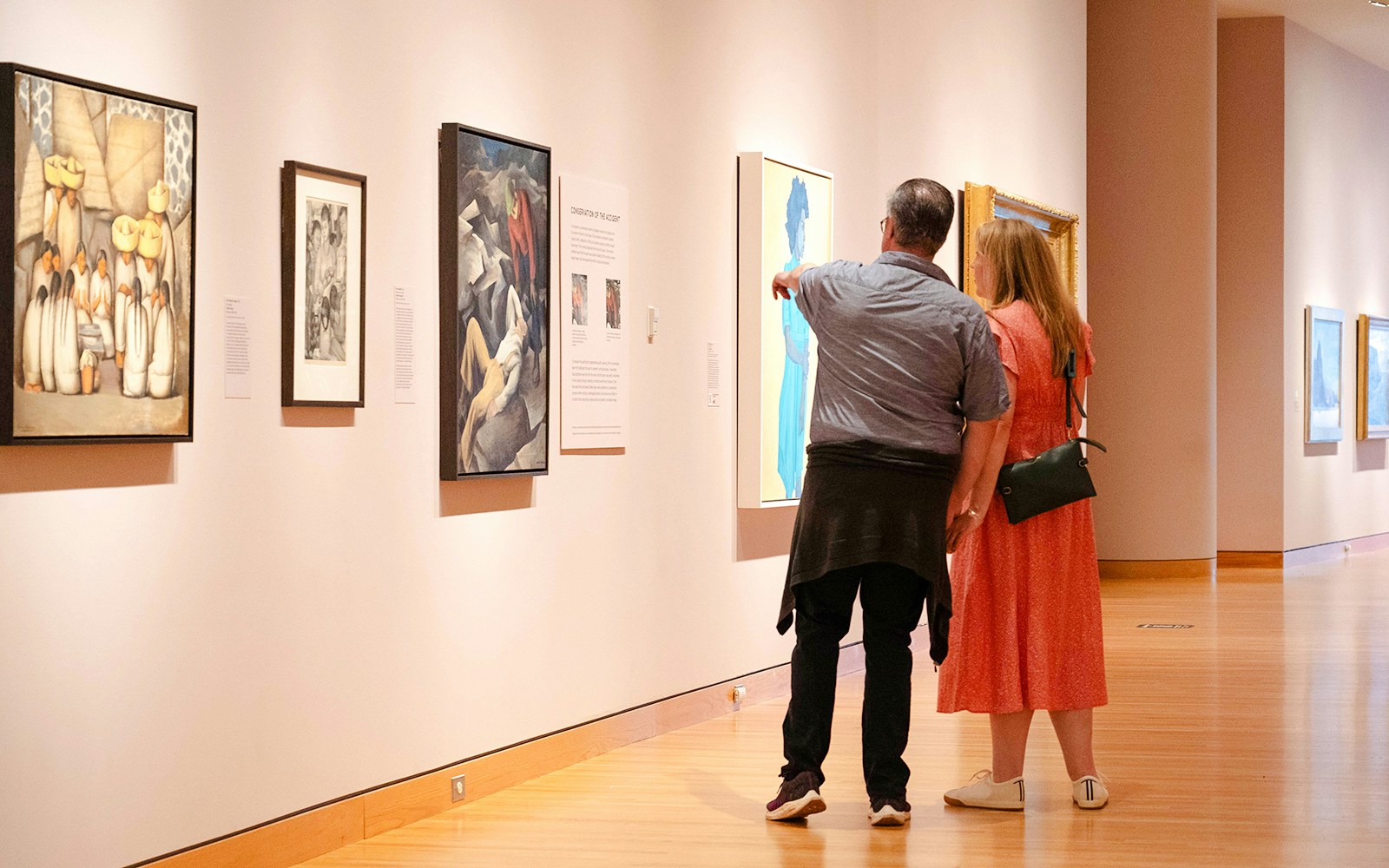 Couple viewing paintings at Seattle Art Museum exhibition.