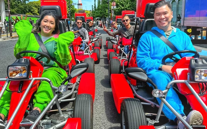 Tourists in costumes driving go-karts on the street in Akihabara, Tokyo.
