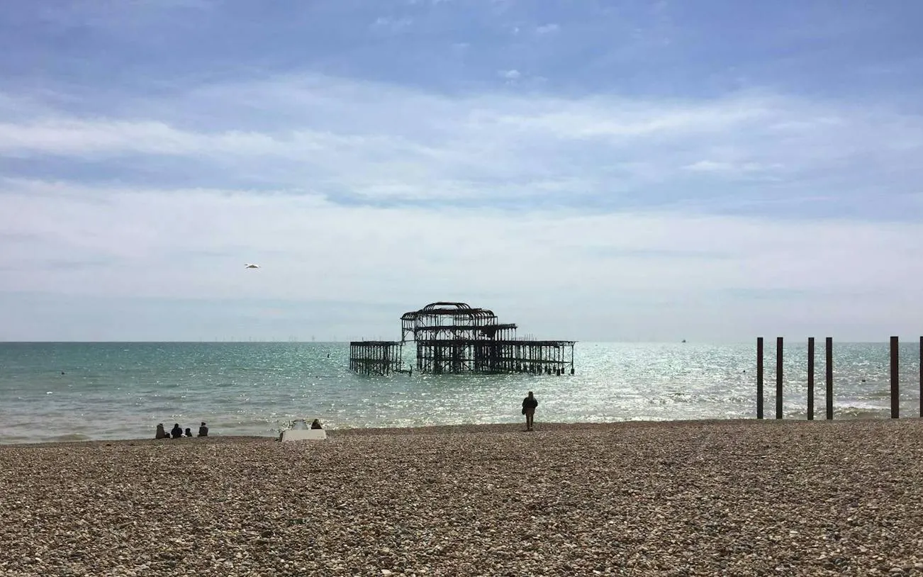 Brighton's West Pier ruins viewed from the pebble beach, part of the self-guided city exploration game.