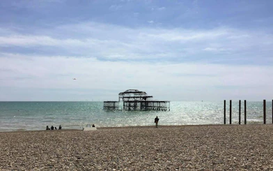 Brighton's West Pier ruins viewed from the pebble beach, part of the self-guided city exploration game.
