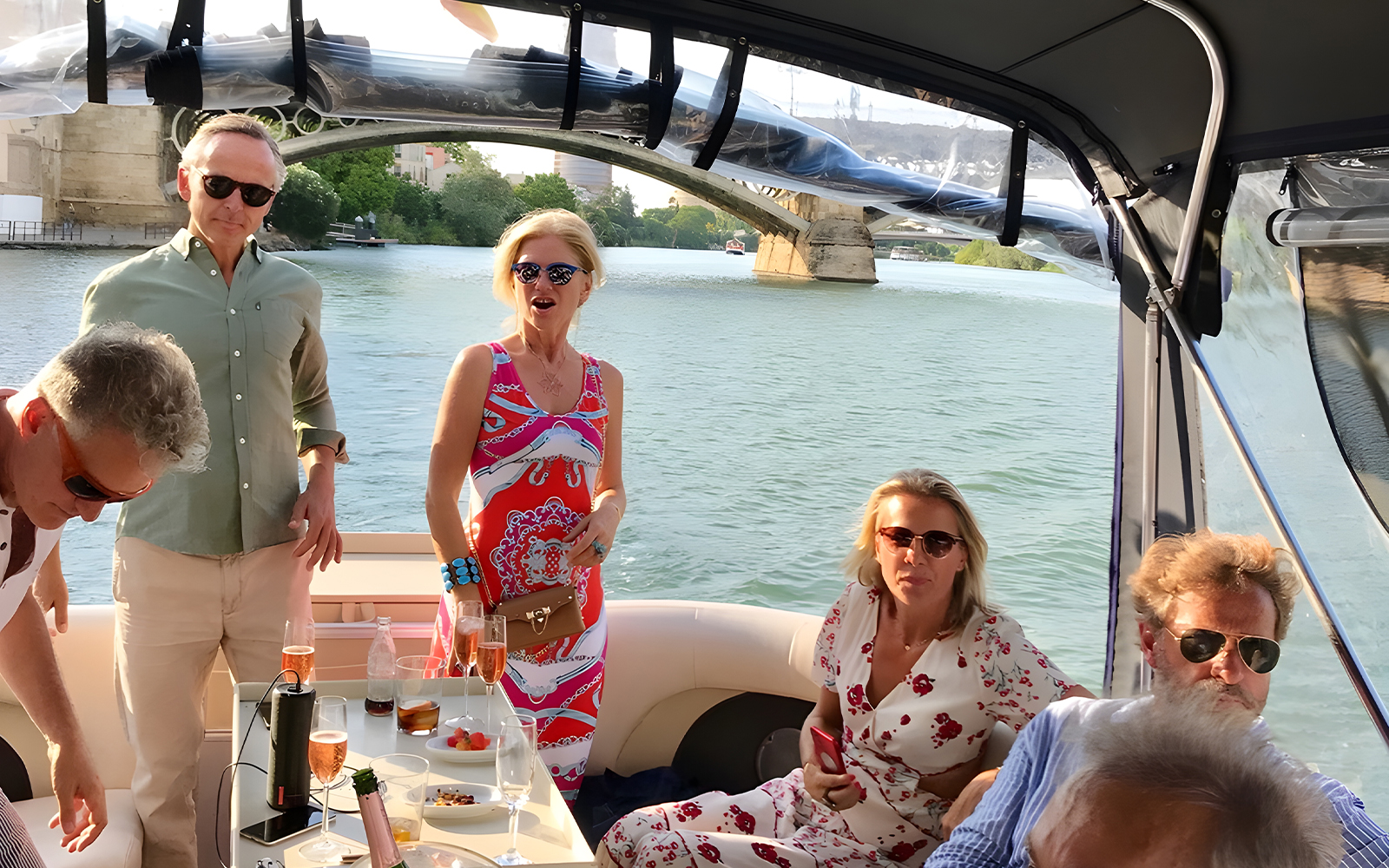Tourists enjoying tapas and drinks on a Guadalquivir River cruise in Seville.