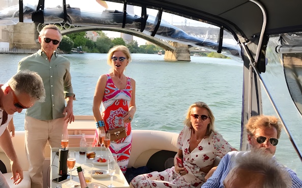 Tourists enjoying tapas and drinks on a Guadalquivir River cruise in Seville.