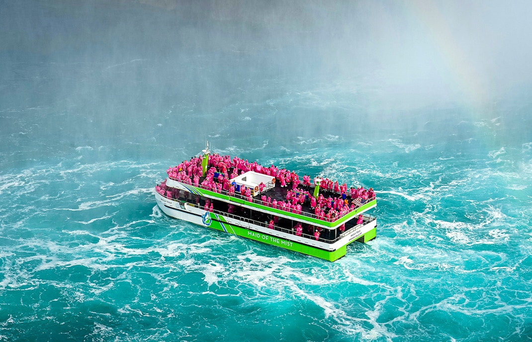 Maid of the Mist boat with passengers in pink ponchos near Niagara Falls.