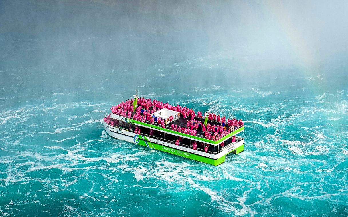 Maid of the Mist boat with passengers in pink ponchos near Niagara Falls.