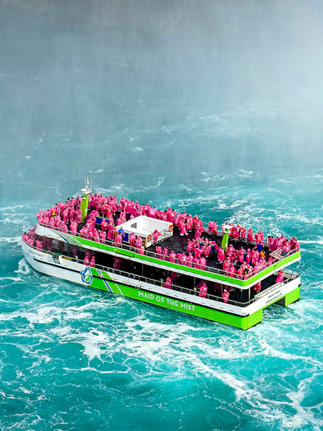 Maid of the Mist boat with passengers in pink ponchos near Niagara Falls.
