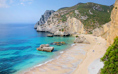 Ribeira do Cavalo Beach with cliffs and clear water, part of a guided snorkeling tour from Lisbon.