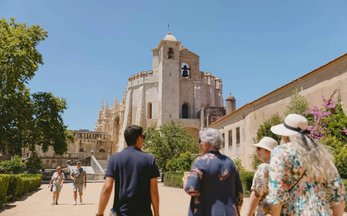 Tourists with guide at Convent of Christ, Tomar, Portugal, exploring Knights Templar site.